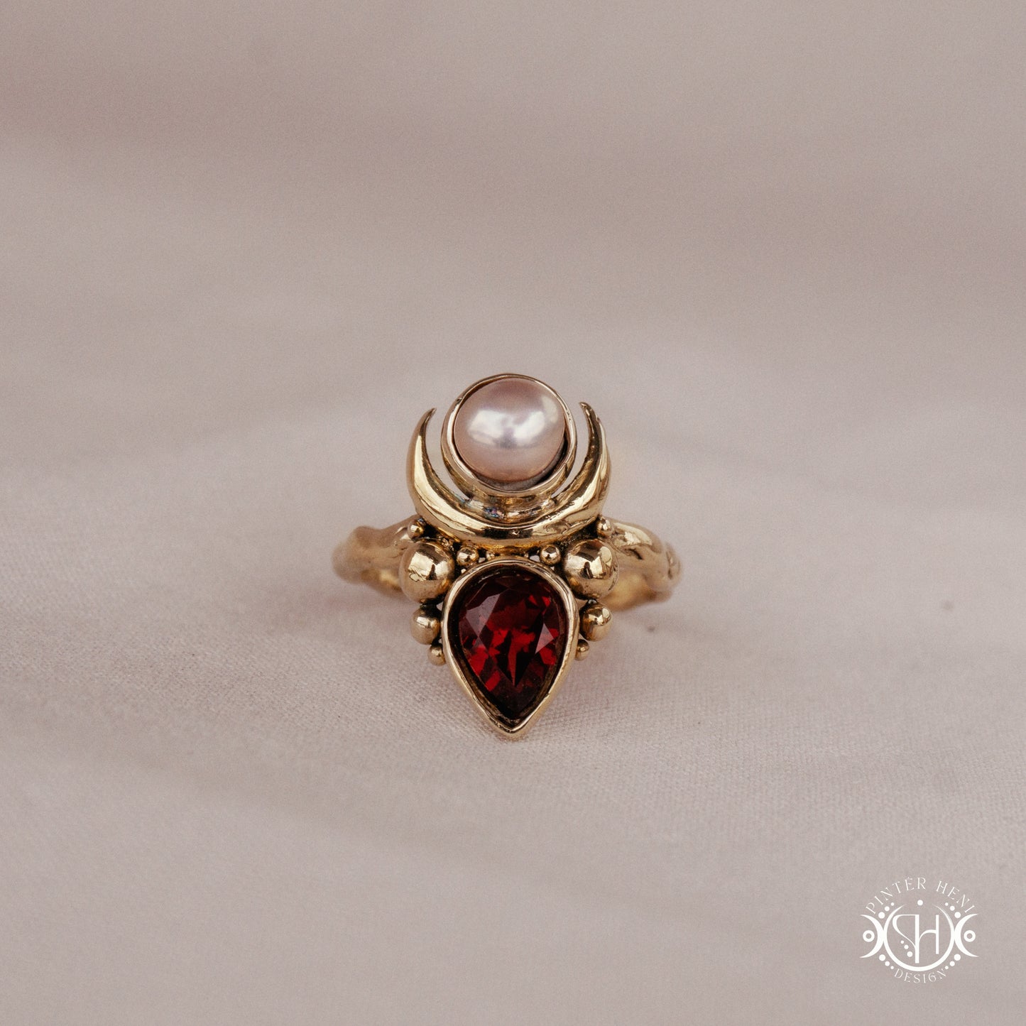 Handmade Hecate ring with garnet and pearl in sculptural feminine design.