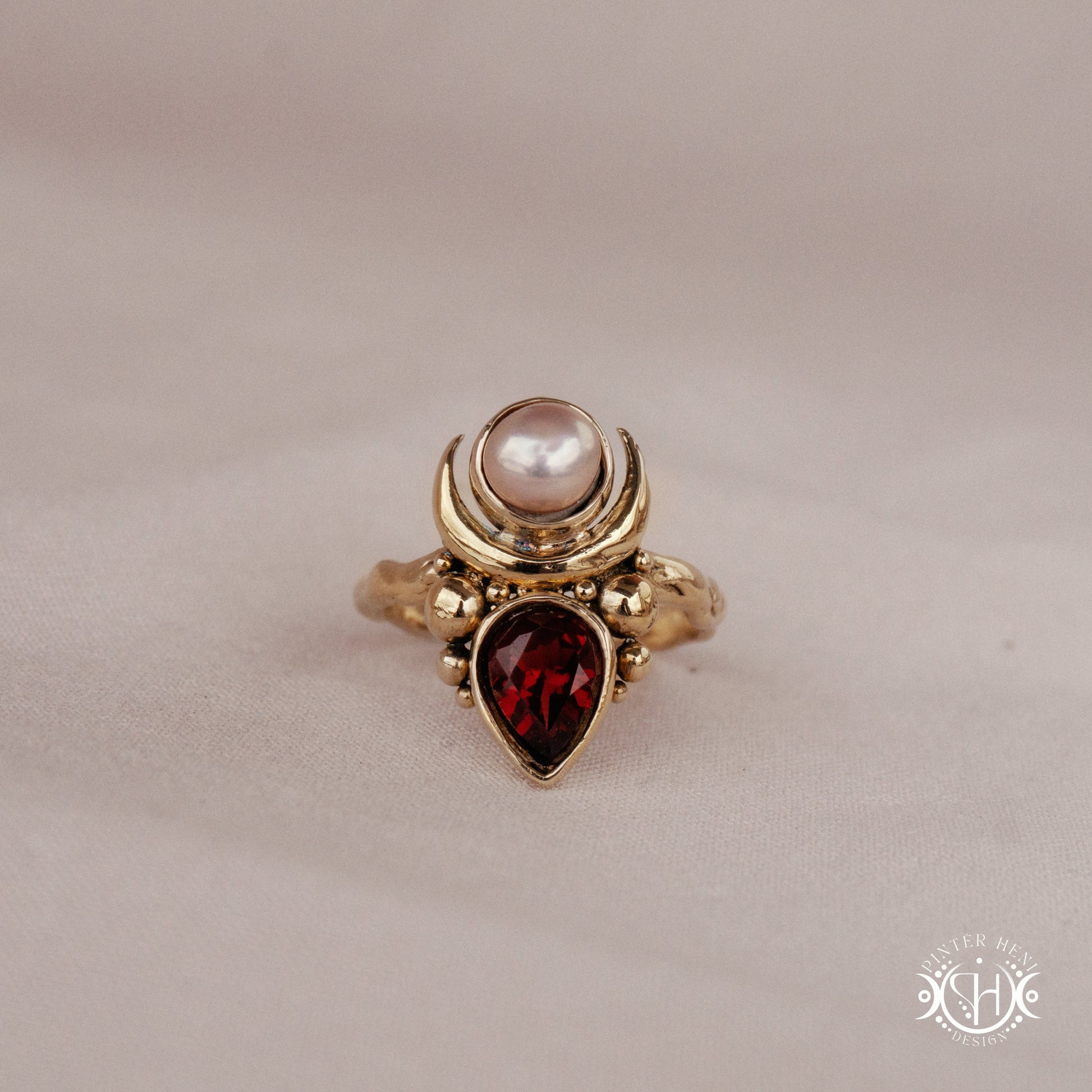 Handmade Hecate ring with garnet and pearl in sculptural feminine design.