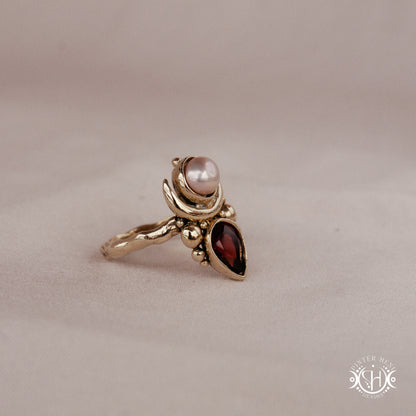 Handmade Hecate ring with garnet and pearl in sculptural feminine design