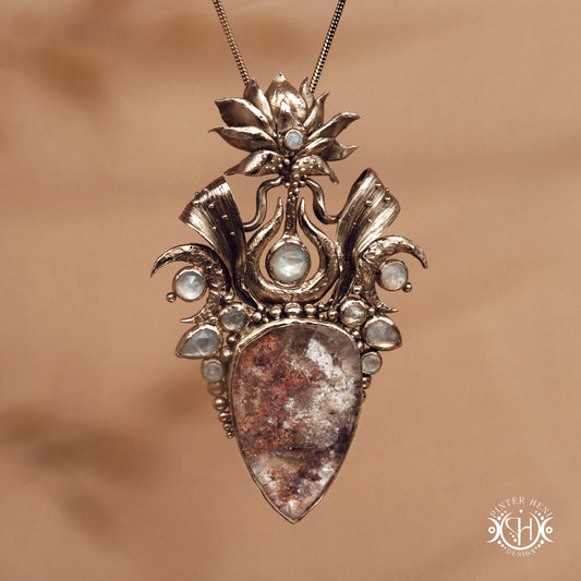 Large brass statement pendant with crystals and gemstones arranged in a crown-like sculptural form, Ishtar’s Oasis necklace.
