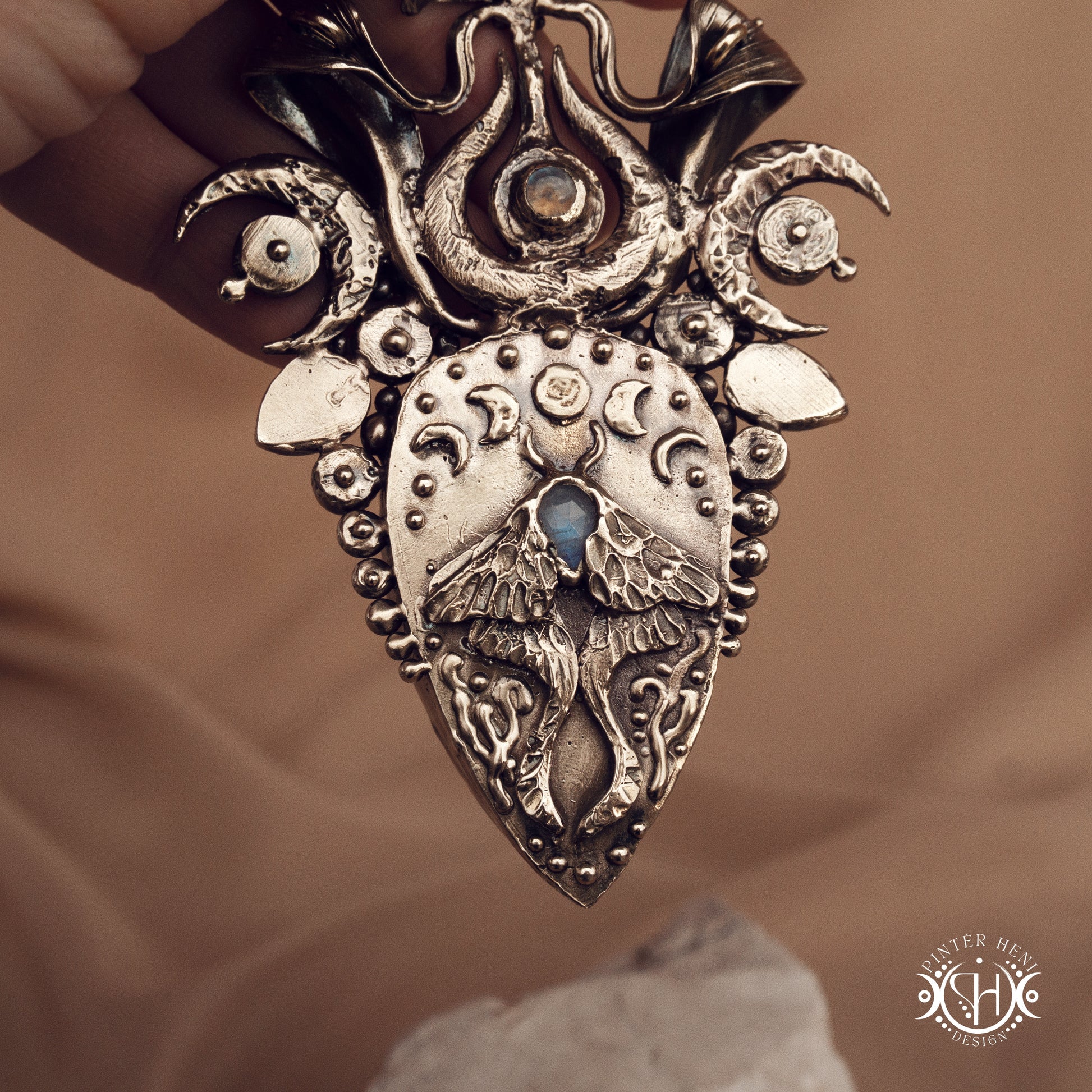 Large brass statement pendant with crystals and gemstones arranged in a crown-like sculptural form, Ishtar’s Oasis necklace.