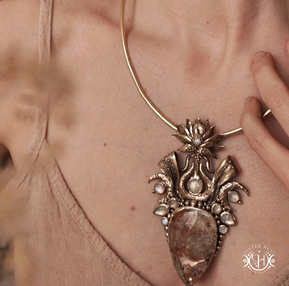 Large brass statement pendant with crystals and gemstones arranged in a crown-like sculptural form, Ishtar’s Oasis necklace.