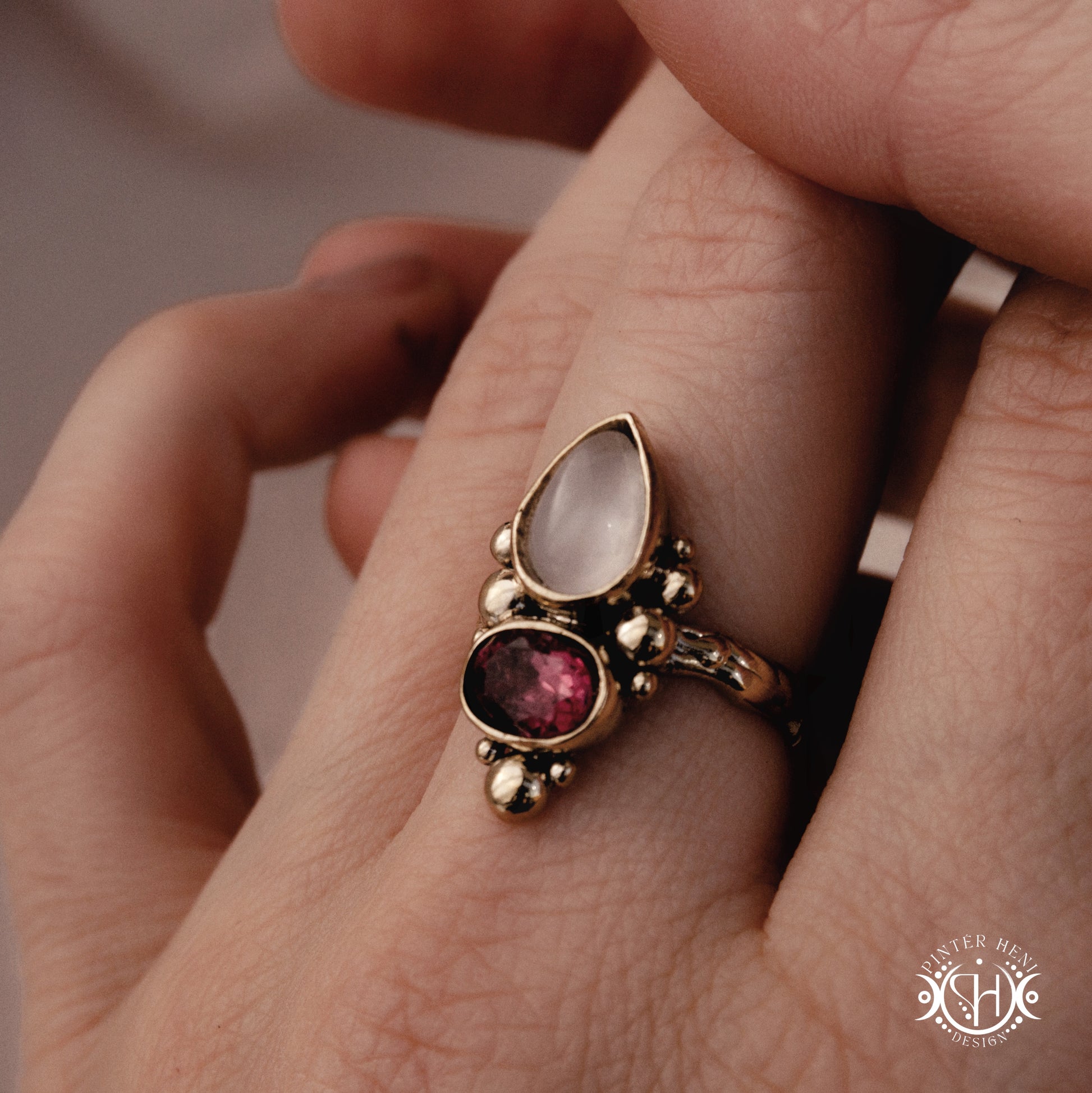  Handmade Kore ring with rose quartz and garnet in balanced sculptural setting, on hand