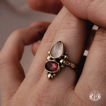  Handmade Kore ring with rose quartz and garnet in balanced sculptural setting, on hand
