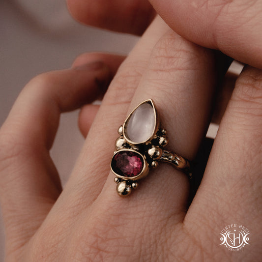  Handmade Kore ring with rose quartz and garnet in balanced sculptural setting, on hand