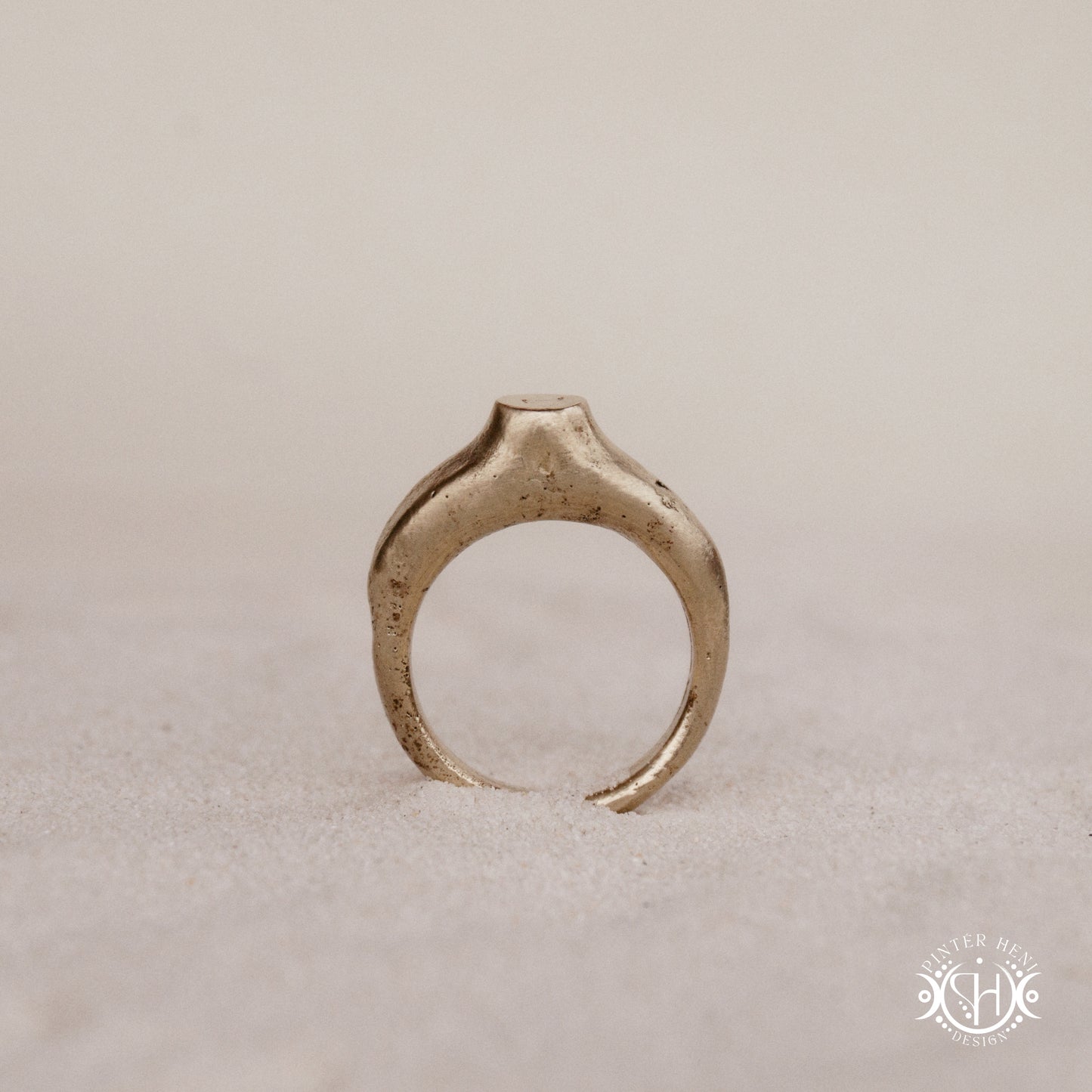 Monolith Ring handmade sandcast brass ring with raised vertical sculptural top, primitive and ancient-inspired form, in sand.