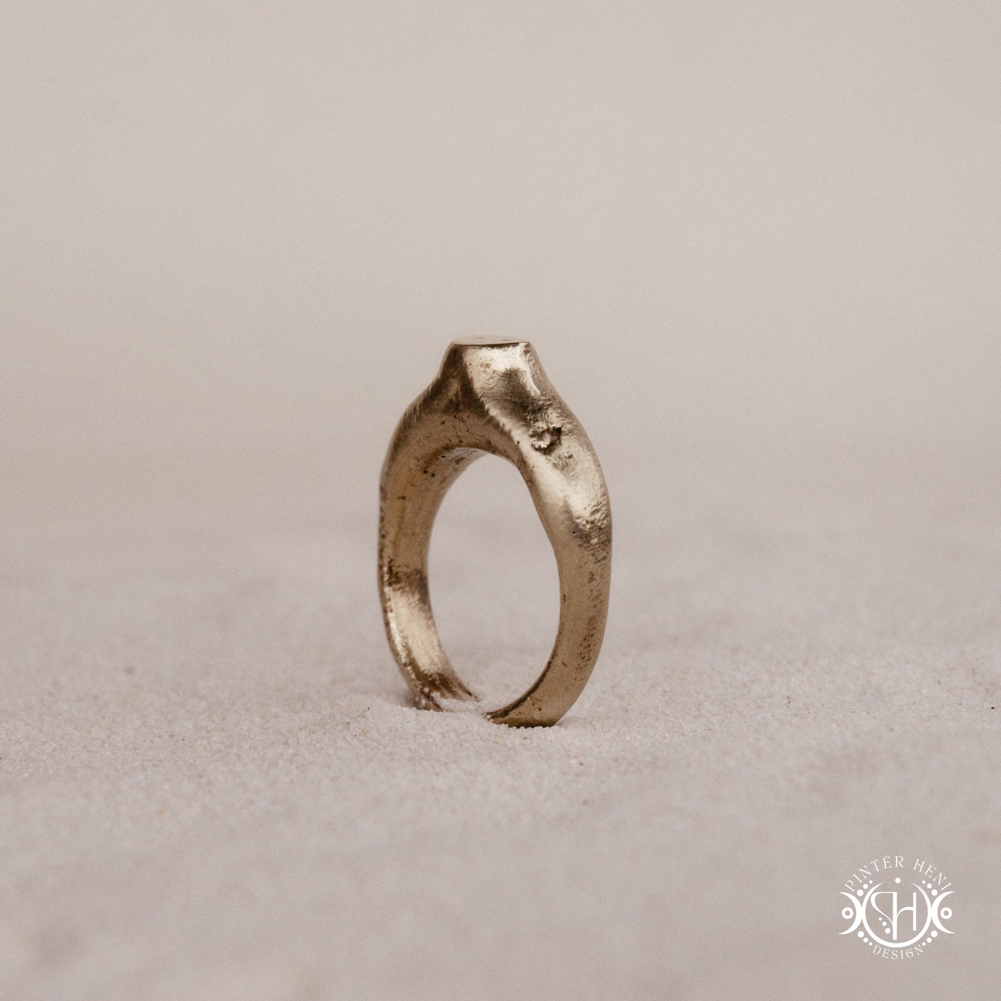 Monolith Ring handmade sandcast brass ring with raised vertical sculptural top, primitive and ancient-inspired form, in sand.