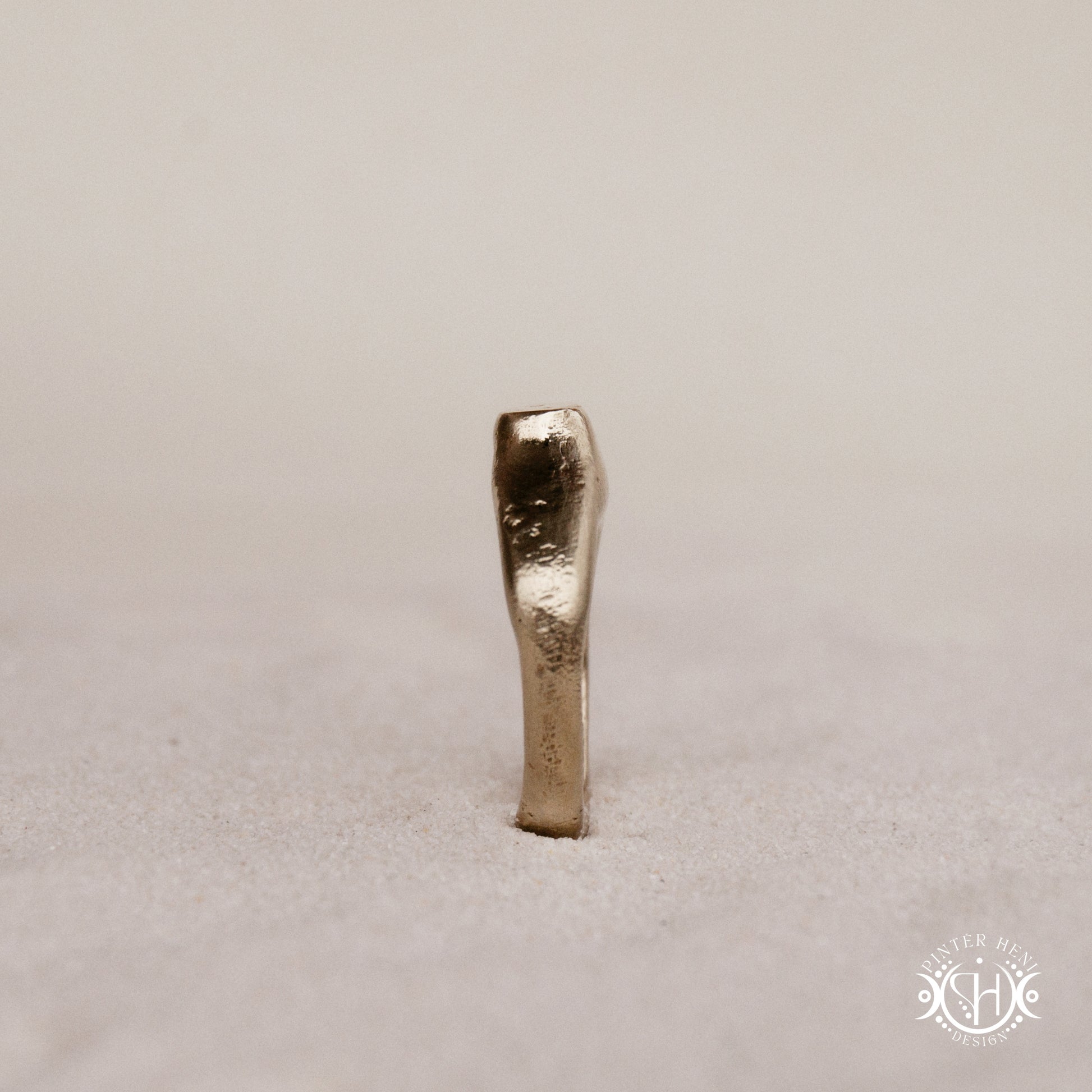 Monolith Ring handmade sandcast brass ring with raised vertical sculptural top, primitive and ancient-inspired form, in sand.