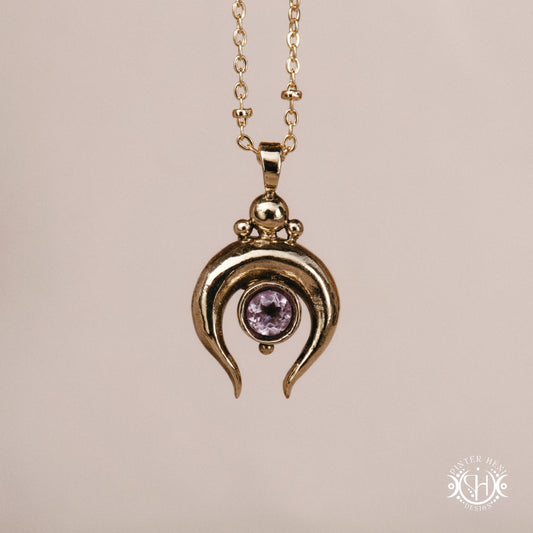 Hand-carved crescent moon pendant in brass with amethyst from the Primal Symbols collection. Symbolic jewelry made to order in brass, silver, and gold.