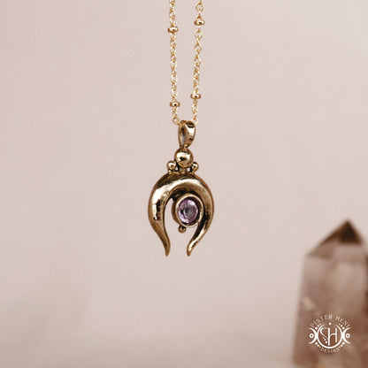 Hand-carved crescent moon pendant in brass with amethyst from the Primal Symbols collection. Symbolic jewelry made to order in brass, silver, and gold.