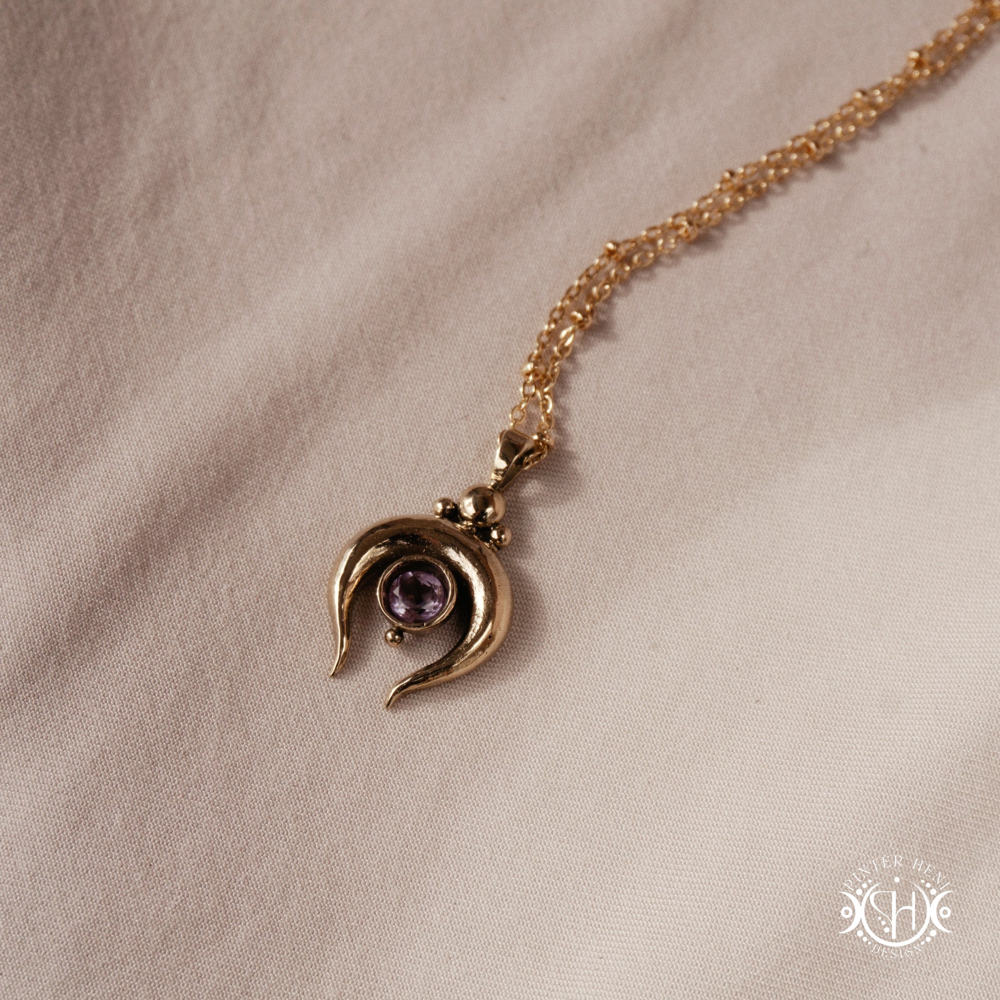 Hand-carved crescent moon pendant in brass with amethyst from the Primal Symbols collection. Symbolic jewelry made to order in brass, silver, and gold.