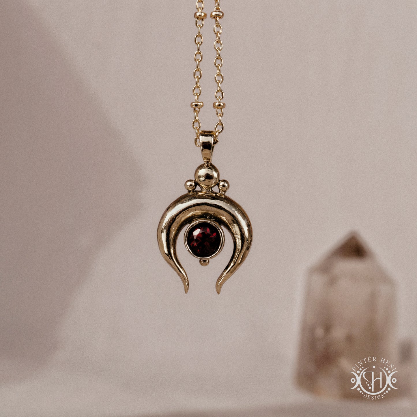 Hand-carved crescent moon pendant in brass with garnet from the Primal Symbols collection. Symbolic jewelry made to order in brass, silver, and gold.