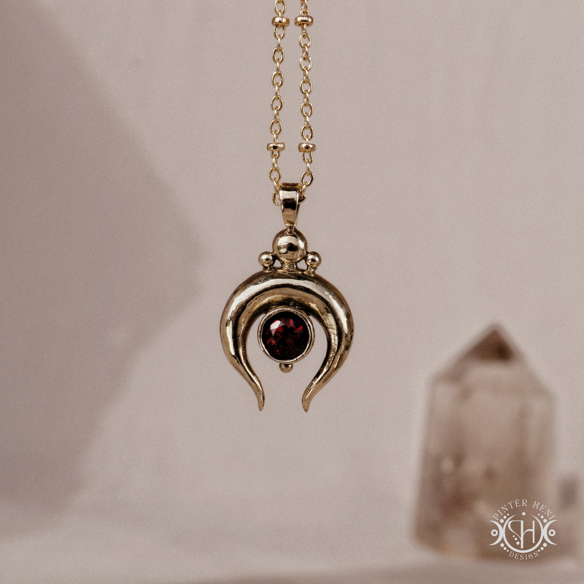 Hand-carved crescent moon pendant in brass with garnet from the Primal Symbols collection. Symbolic jewelry made to order in brass, silver, and gold.