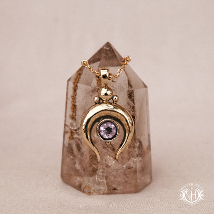Hand-carved crescent moon pendant in brass with amethyst from the Primal Symbols collection. Symbolic jewelry made to order in brass, silver, and gold.