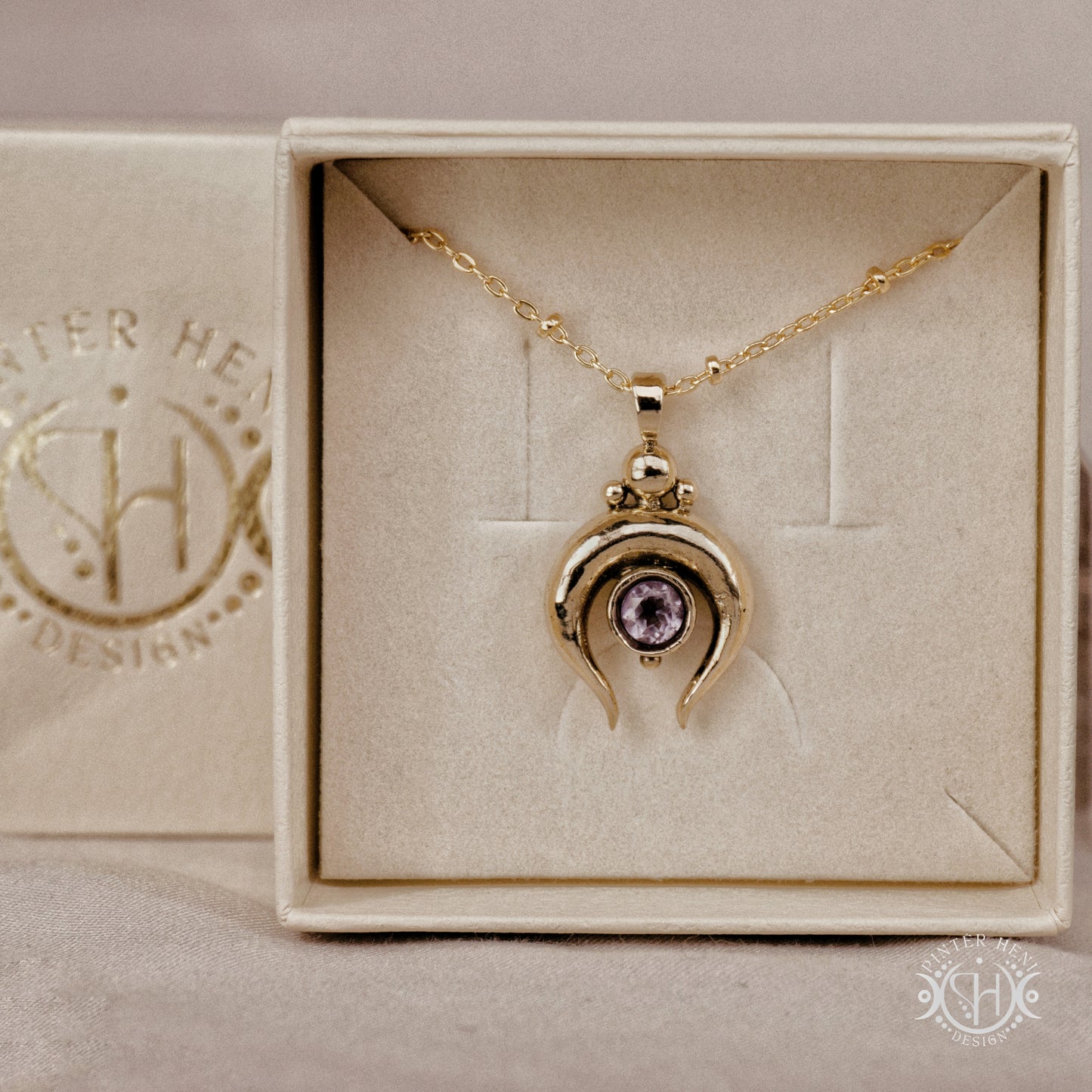 Hand-carved crescent moon pendant in brass with amethyst from the Primal Symbols collection. Symbolic jewelry made to order in brass, silver, and gold.