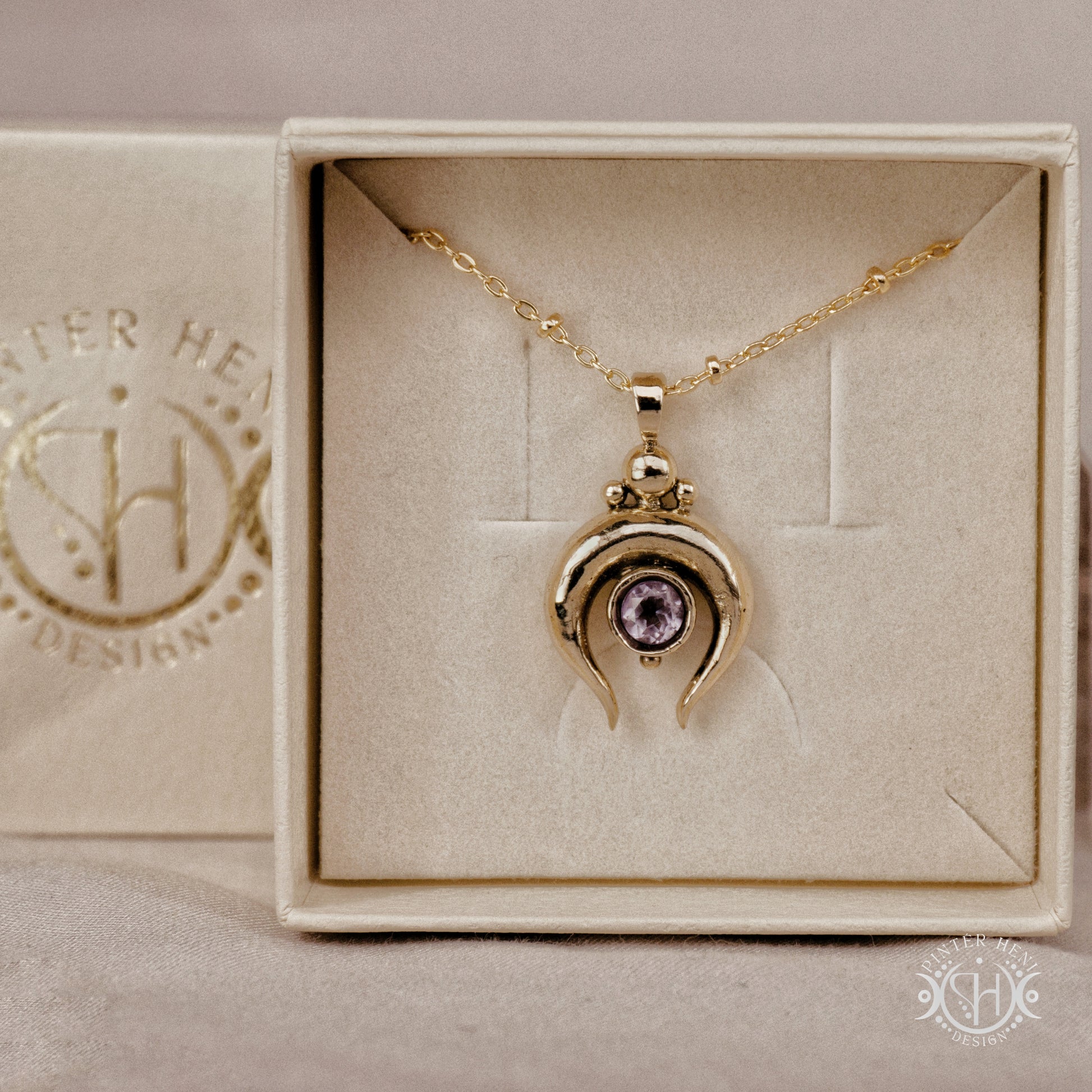 Hand-carved crescent moon pendant in brass with amethyst from the Primal Symbols collection. Symbolic jewelry made to order in brass, silver, and gold.