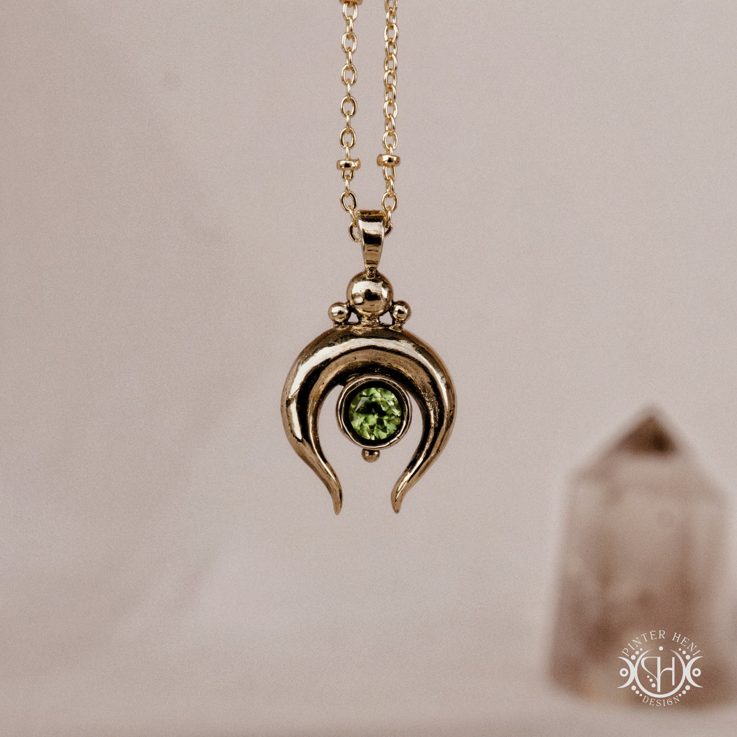 Hand-carved crescent moon pendant in brass with peridot from the Primal Symbols collection. Symbolic jewelry made to order in brass, silver, and gold.