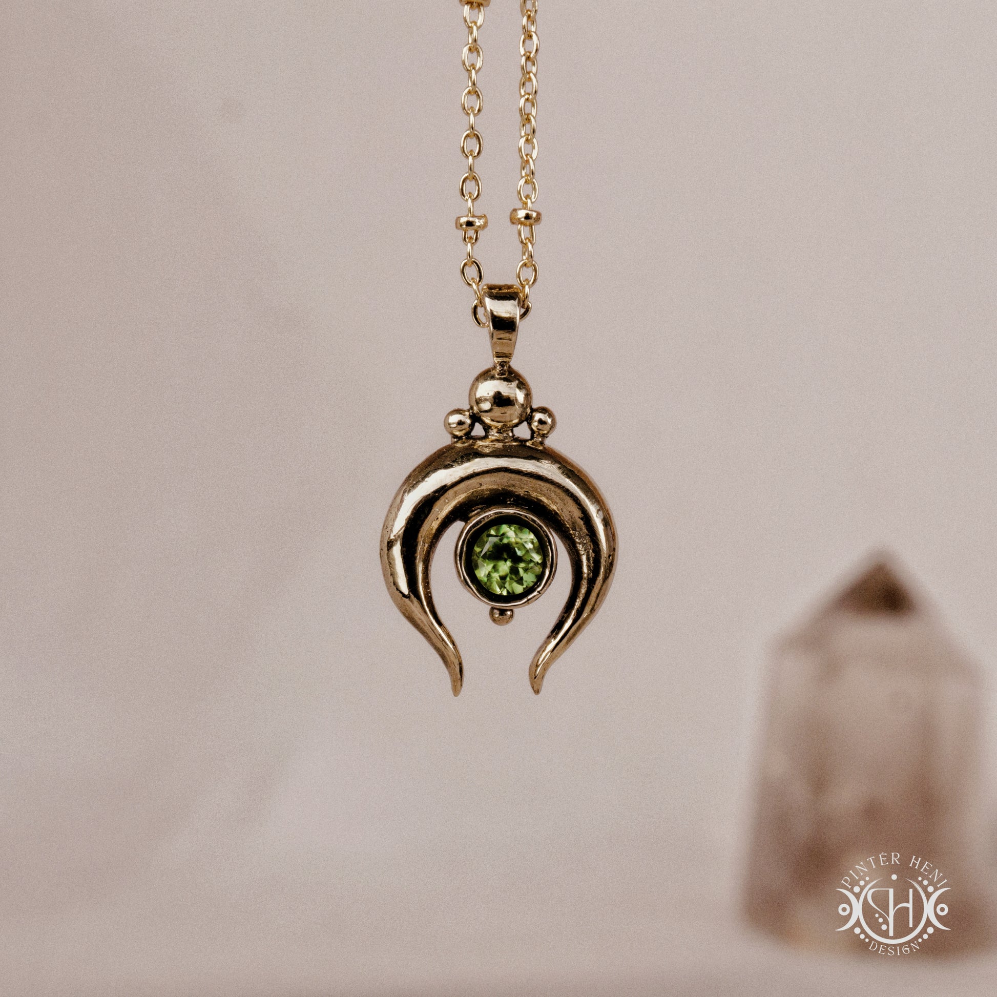 Hand-carved crescent moon pendant in brass with peridot from the Primal Symbols collection. Symbolic jewelry made to order in brass, silver, and gold.