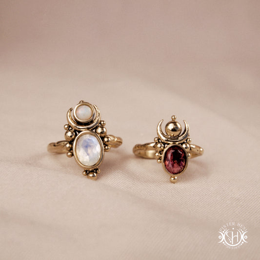 Hand-carved Nyx rings with opal, moonstone and garnet in brass, sculptural crescent design.