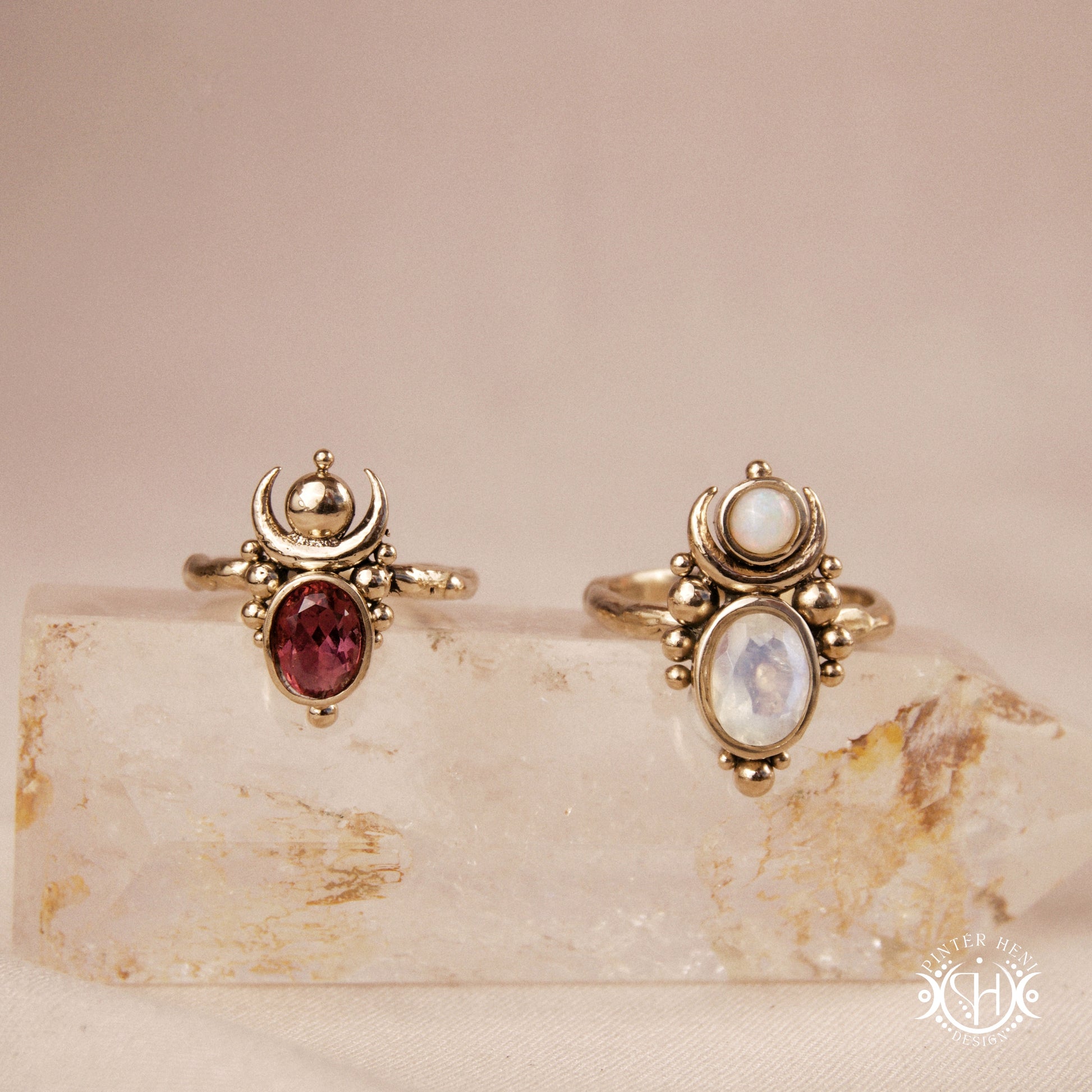 Hand-carved Nyx rings with opal, moonstone and garnet, on crystal.