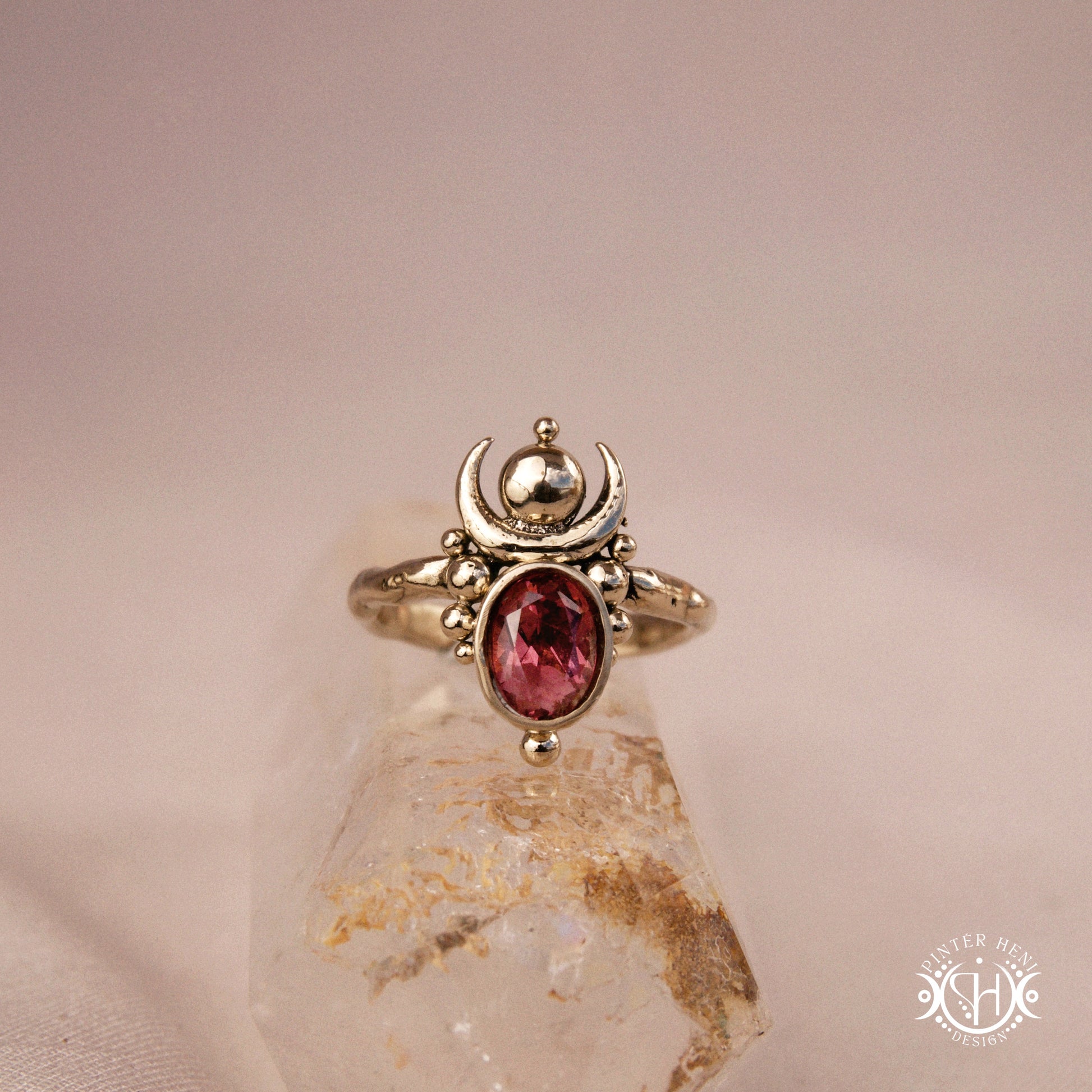Hand-carved Nyx ring with opal and garnet, compact vertical sculptural form, on crystal.