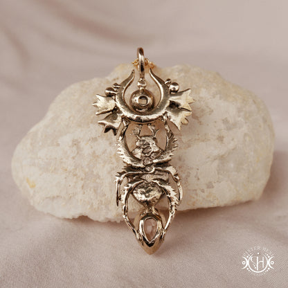 Scarab pendant in brass with moonstone and morganite, back view, on a textured surface