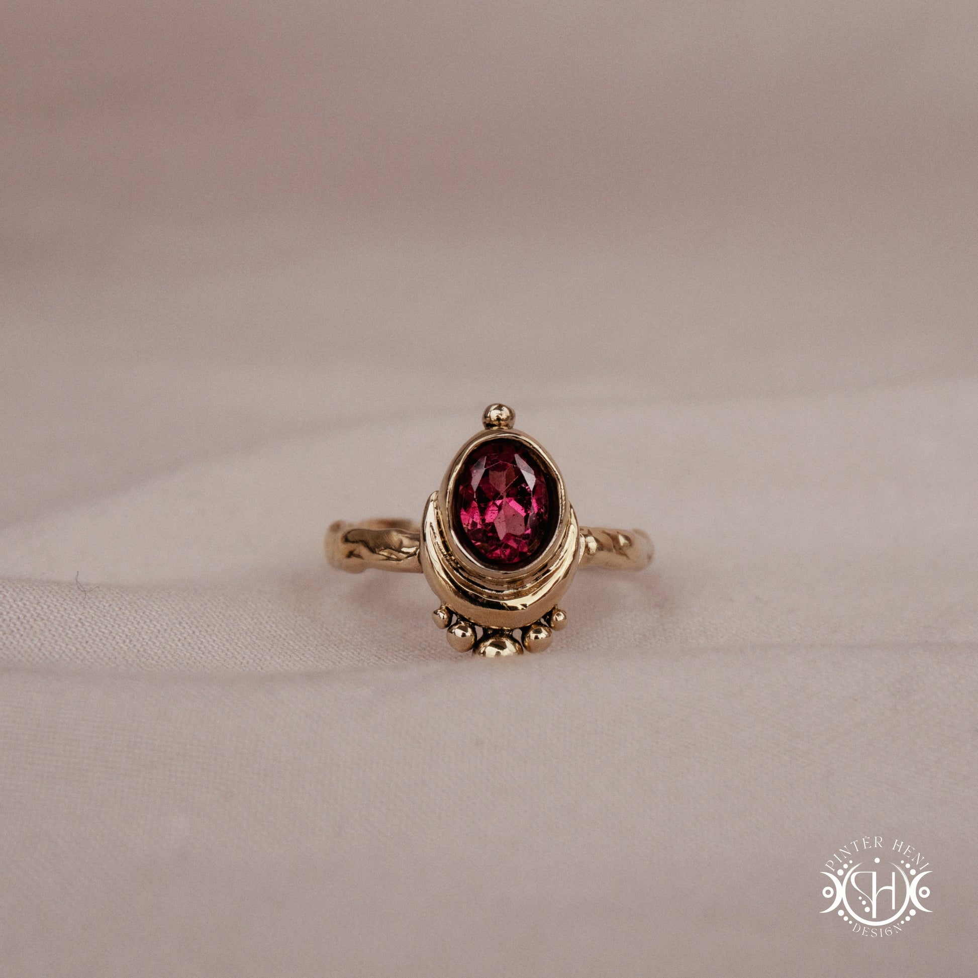 Handmade oval garnet gemstone ring set within a crescent-inspired form