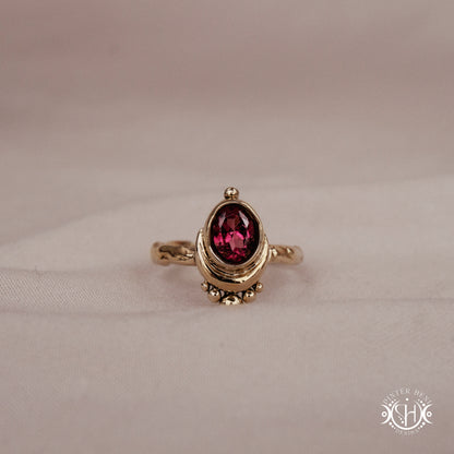 Handmade oval garnet gemstone ring set within a crescent-inspired form