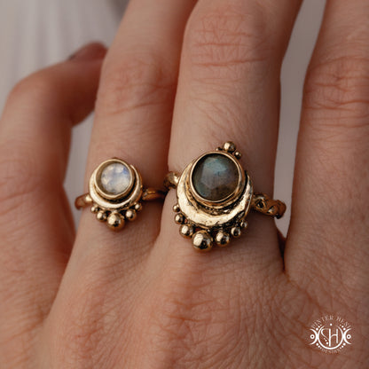 Handmade crescent moon ring with round moonstone set inside the lunar curve, worn on hand.