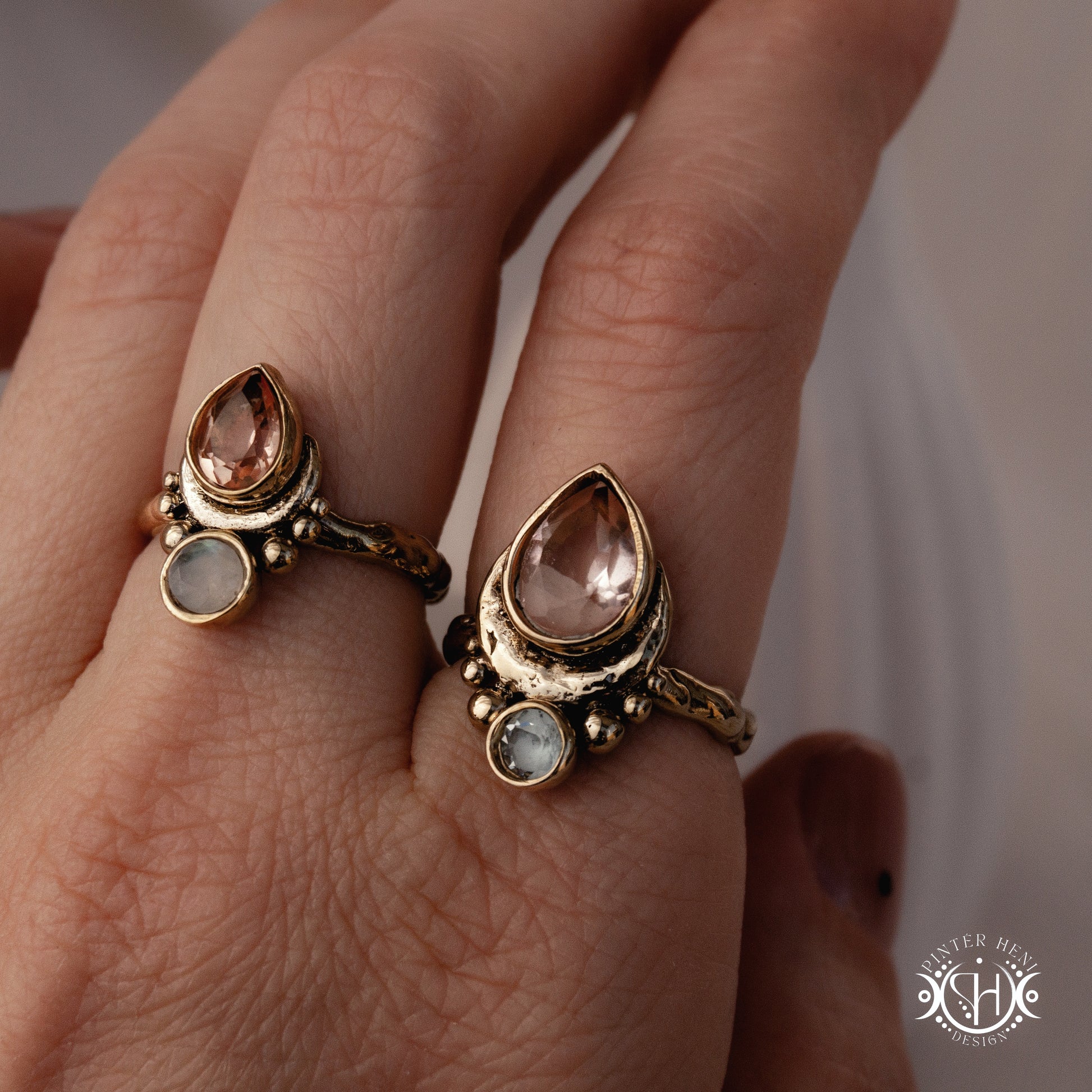Handmade teardrop rings with morganite, moonstone and aquamarine set in crescent-inspired form, worn on hand