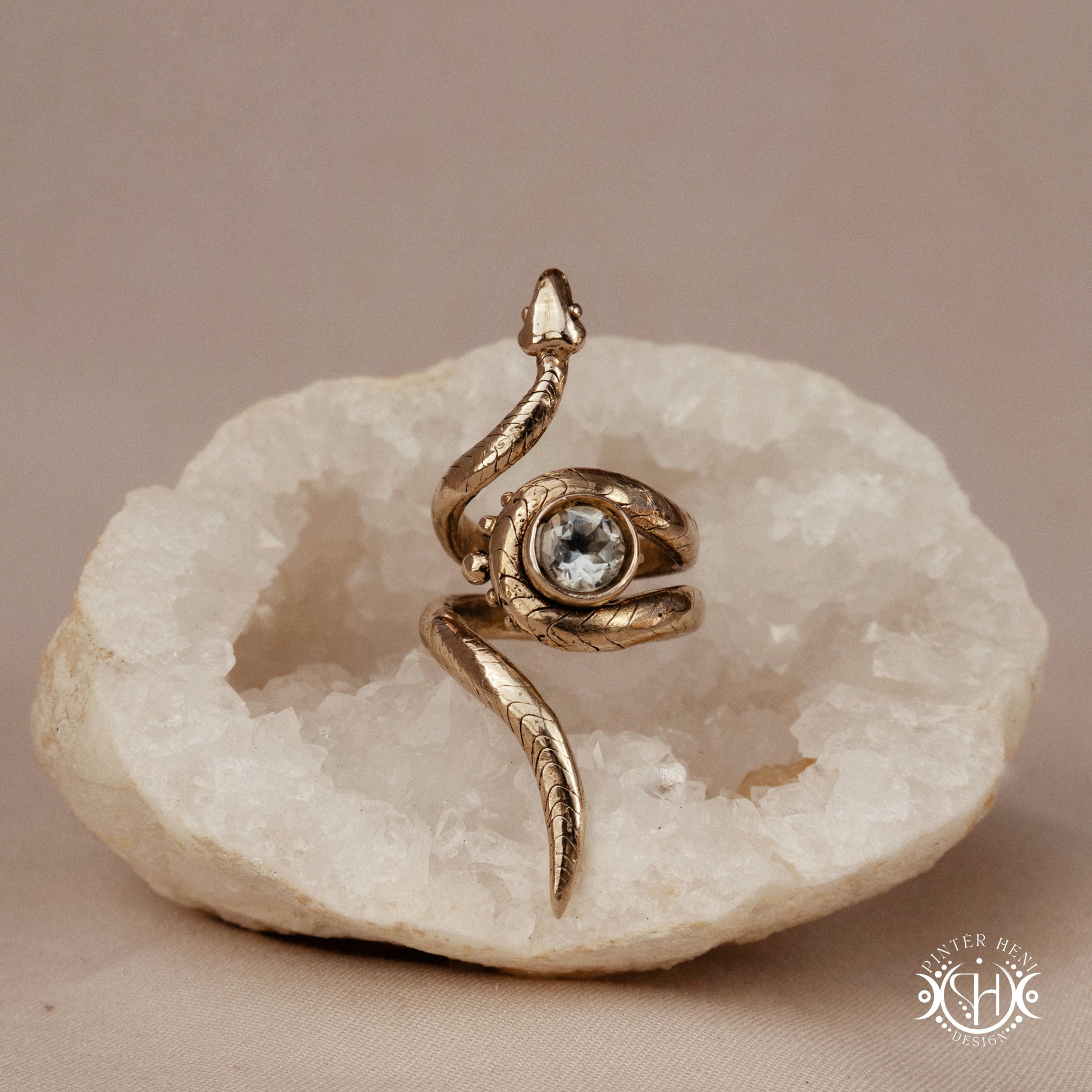 Handmade adjustable serpent ring set with prasiolite, sculptural wax carved design in brass, silver, or solid gold, on a crystal.