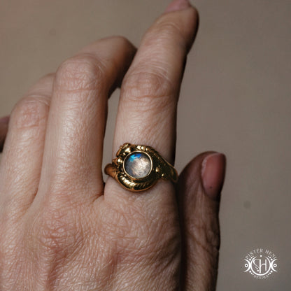 Handmade serpent ring set with moonstone, sculptural wax carved design in brass, worn on hand.