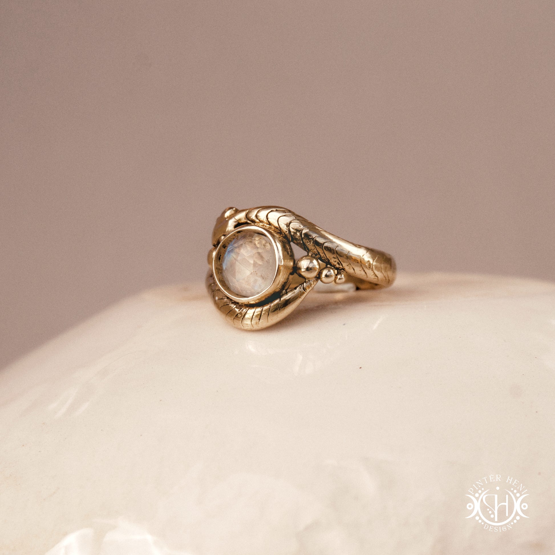 Handmade serpent ring set with moonstone, sculptural wax carved design in brass, silver, or solid gold, side view.