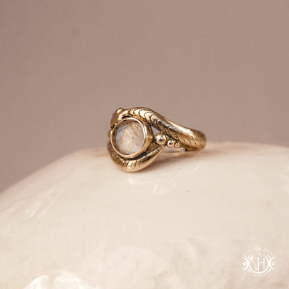 Handmade serpent ring set with moonstone, sculptural wax carved design in brass, silver, or solid gold, side view.