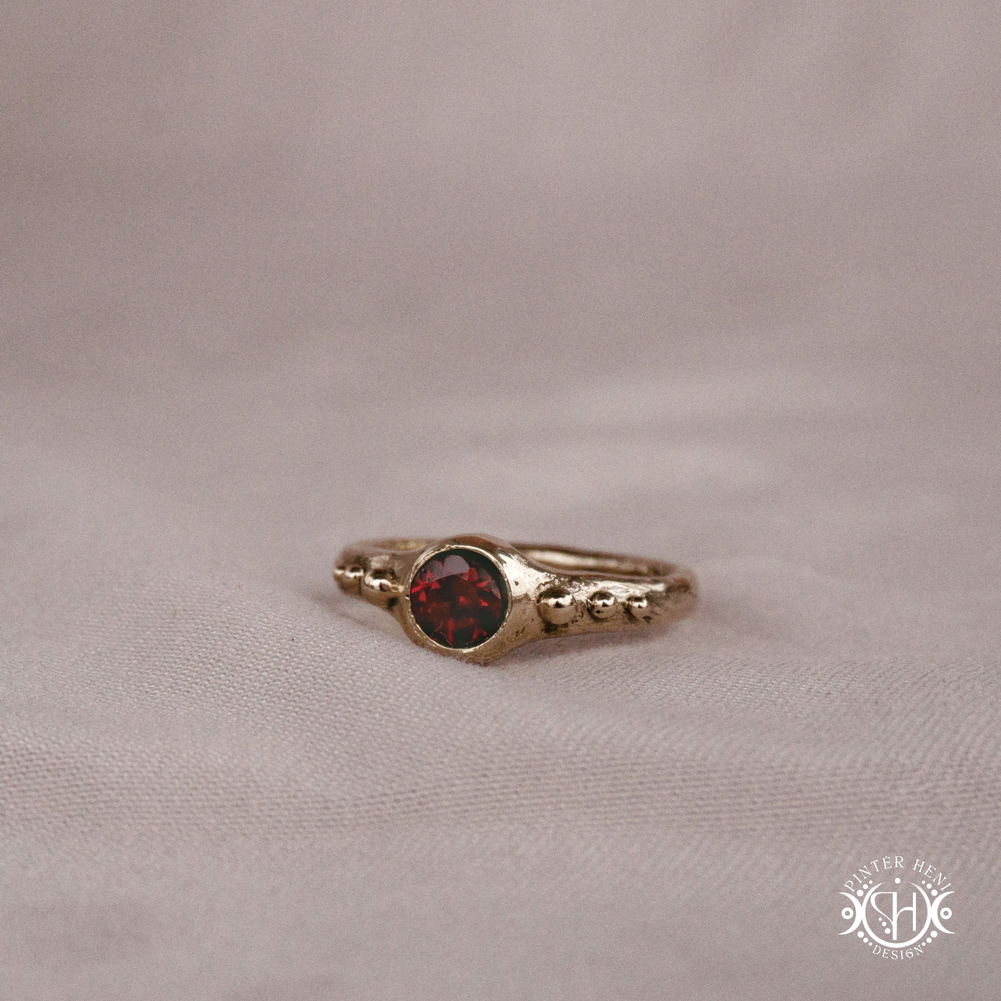 Star Cluster Ring with garnet and surrounding bead details in handcrafted metal