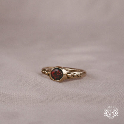Star Cluster Ring with garnet and surrounding bead details in handcrafted metal