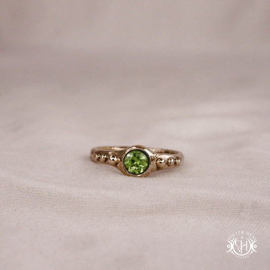Star Cluster Ring with peridot and surrounding bead details in handcrafted metal