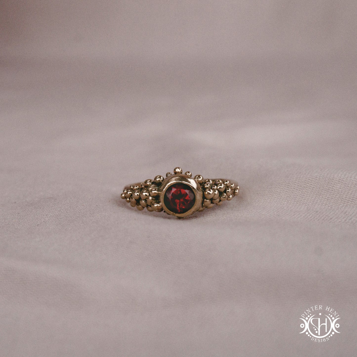 Supernova Core Ring with garnet and clustered bead texture forming an upper arc in handcrafted metal