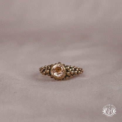 Supernova Core Ring with morganite and clustered bead texture forming an upper arc in handcrafted metal