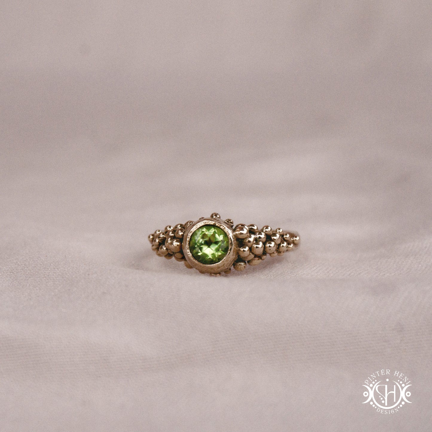 Supernova Core Ring with peridot and clustered bead texture forming an upper arc in handcrafted metal