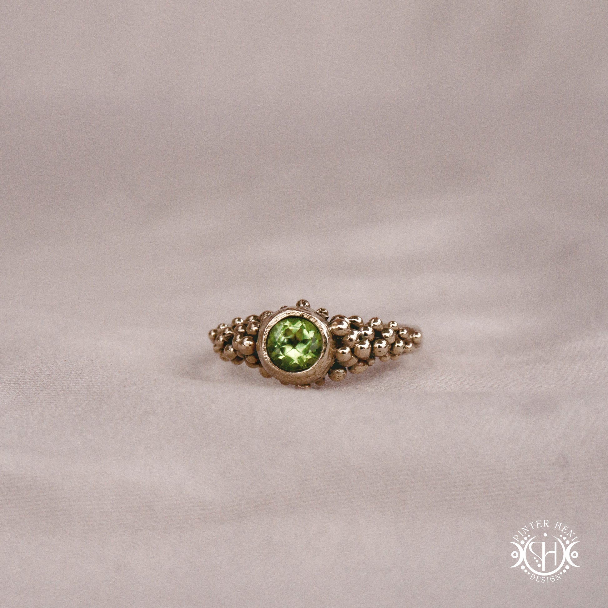 Supernova Core Ring with peridot and clustered bead texture forming an upper arc in handcrafted metal
