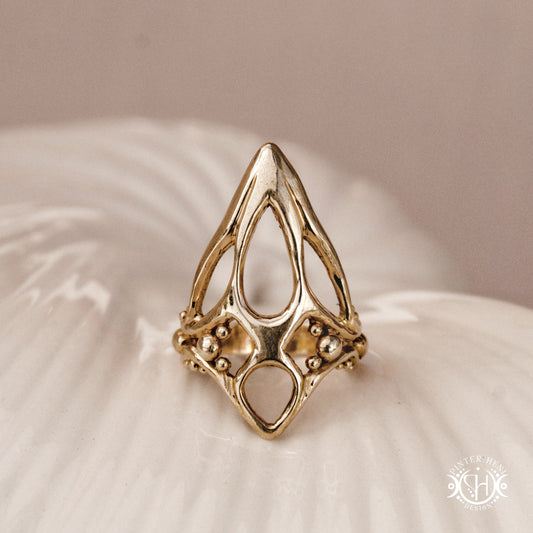 Void Ring open sculptural axial handmade ring with negative space organic structure, on ceramic surface.